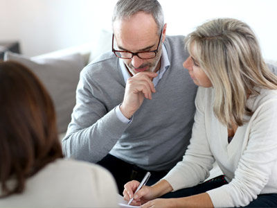 A couple discuss a contract of sale with their conveyancer