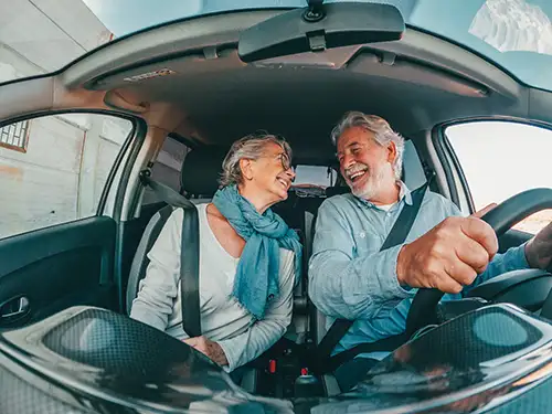 Interior of a car with an elder couple celebrating their new car purchase
