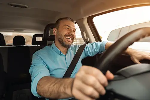 Working man in car with hands on steering wheel