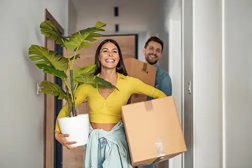 Couple moving boxes into their new apartment
