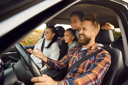 Family in a car with husband driving