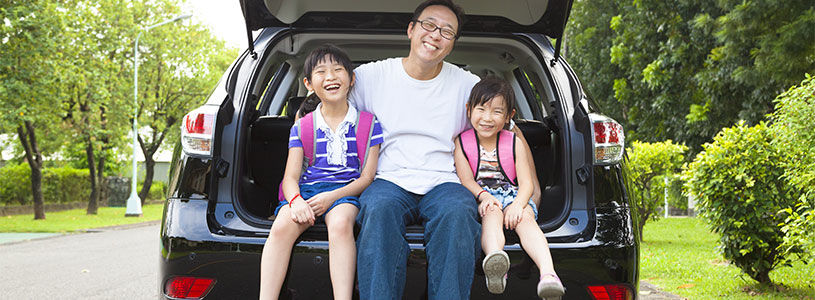 family happy sitting on open boot