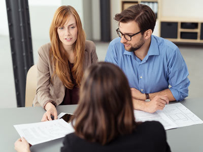 a couple discusses their investment loan options with a finance broker